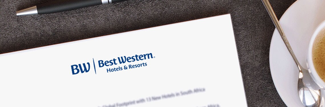 Best Western stationary and  pen next to a cup of coffee