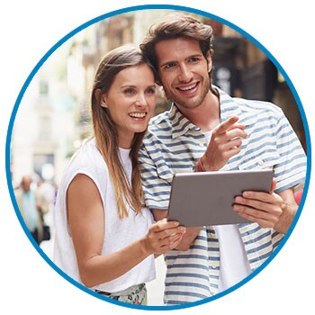 Young man and woman with tablet exploring an city