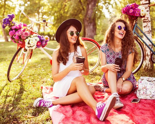 Two girls having a picnic with bicycles behind them
