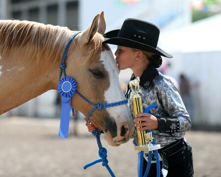 Image of girl kissing prize-winning horse