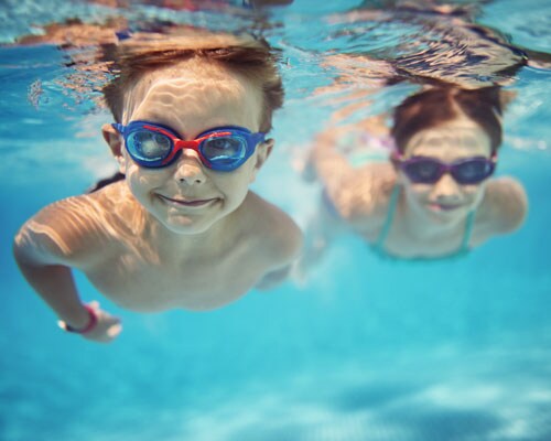 Kids swimming underwater with goggles