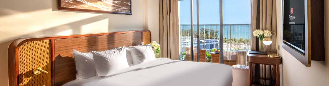 Guest room of bed looking out to the water.