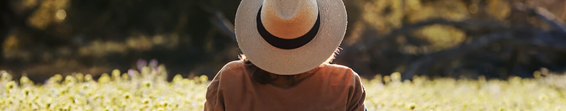 person with hat reclining in the grass