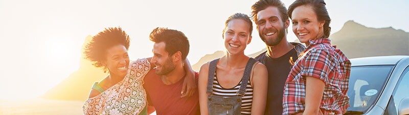 People at sunset in front of car