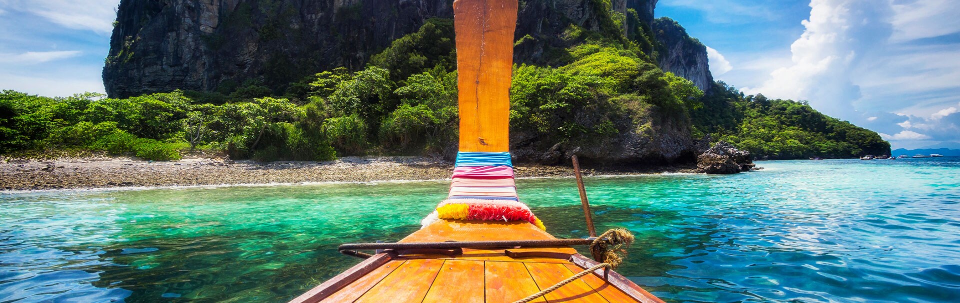 Long tail boat approaching island in Thailand