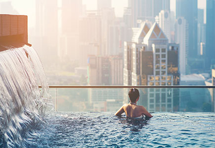 Girl in pool overlooking the city